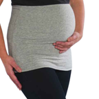 A close-up of a pregnant person wearing a light grey maternity tummy band over a black top and black leggings, with both hands resting on the belly, against a plain white background.