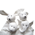 Four white organic cotton baby comforters shaped like a rabbit, a bear, a monkey, and an elephant, with black embroidered facial features, set against a plain white background.
