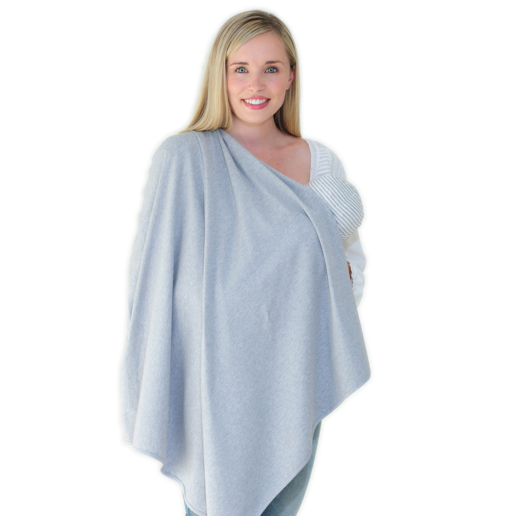 A woman modelling a grey nursing wrap blanket or burrito wrap, worn over a white knit top, against a solid white background.