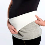 Person wearing a reversible maternity band on a plain background